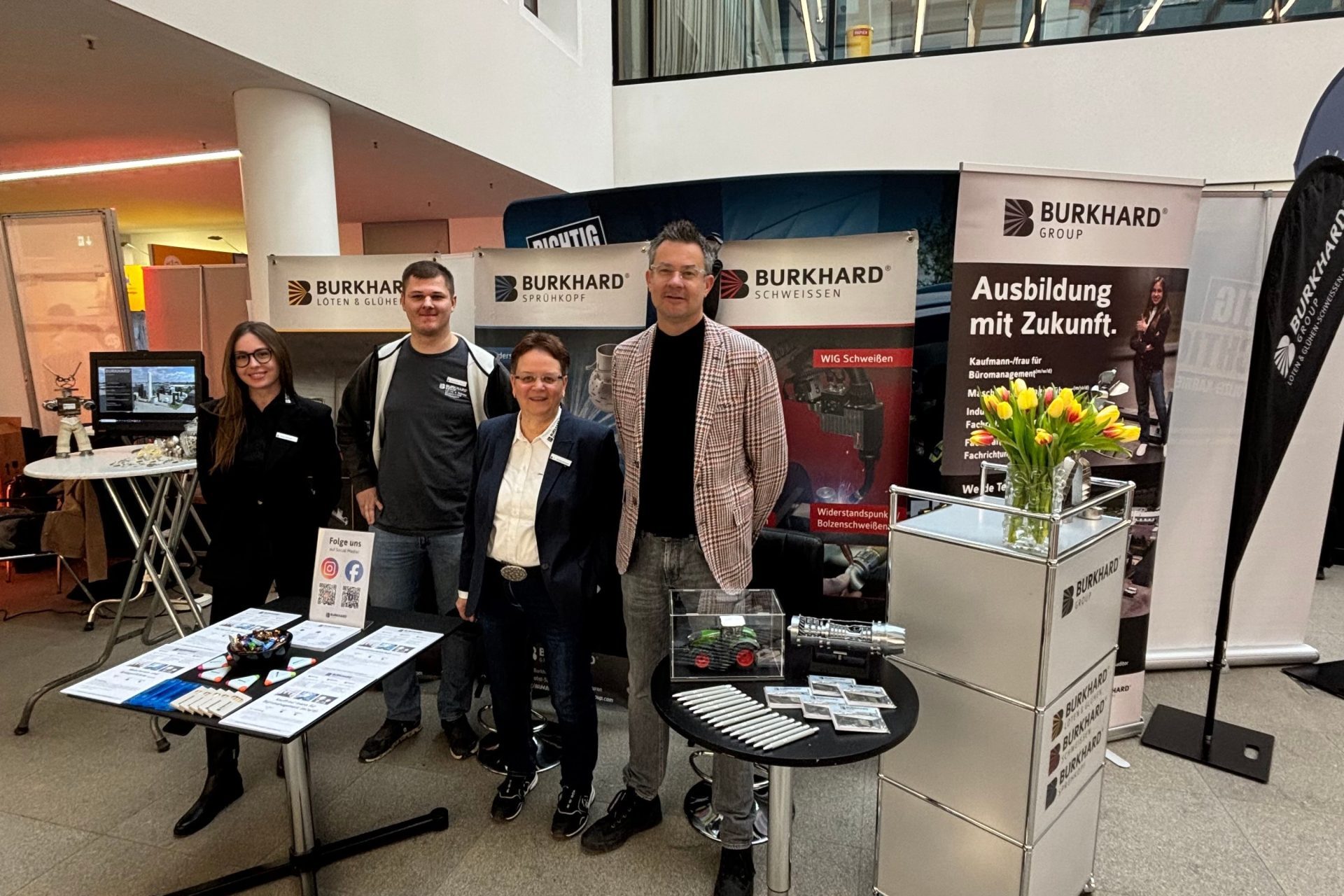 Team der Burkhard Group an einem Messestand in einer Ausstellungshalle