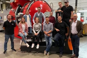 Auszubildende, Ausbilder und Geschäftsführung der BURKHARD GROUP vor dem neuen Hochvakuumofen in Kaufbeuren